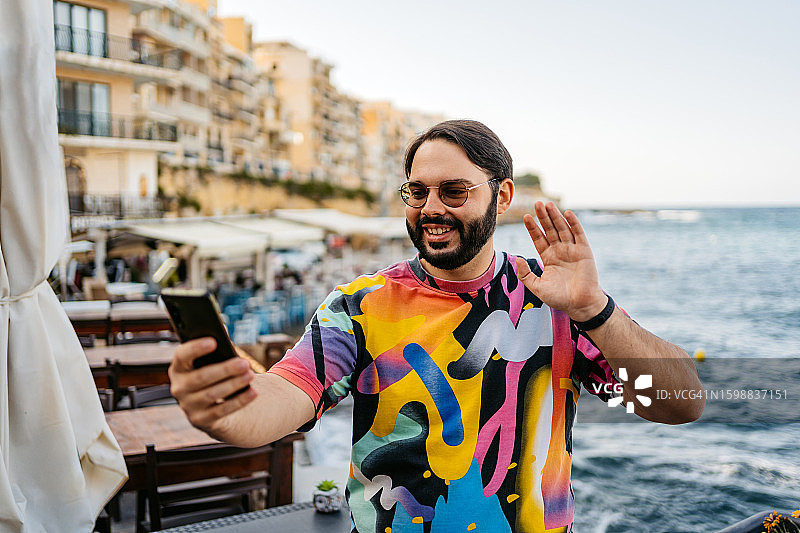 年轻男子在马耳他咖啡馆用手机进行视频通话图片素材