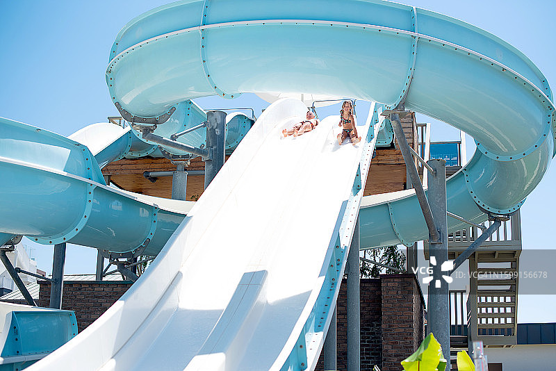 快乐的孩子们在水上乐园的水滑梯上泼水图片素材