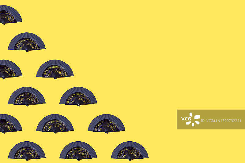 黄色背景上的蓝色手扇图案图片素材