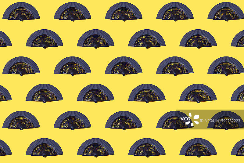 黄色背景上的蓝色扇子图案。炎热、传统、热、风、凉爽、降温、财富、亚洲和西班牙概念图片素材
