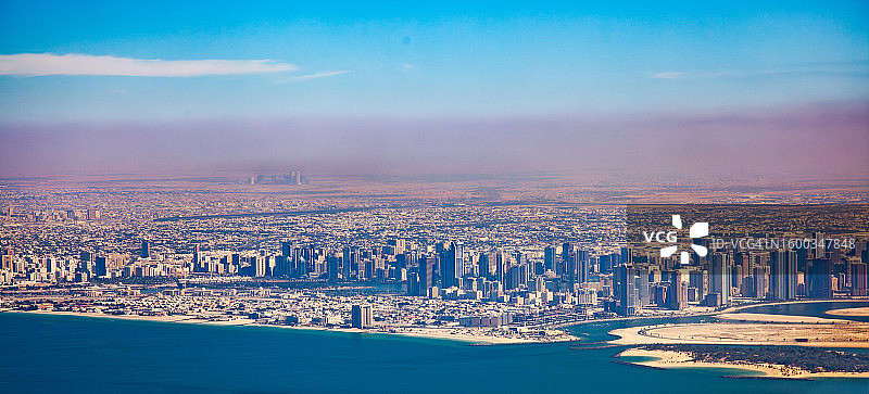 雾中的迪拜，有摩天大楼和海岸线的航拍图片素材
