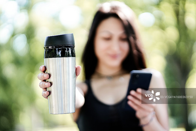 女人在公园里拿着可重复使用的杯子特写图片素材