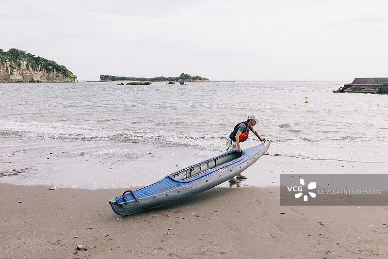 准备皮划艇探险的日本男人图片素材