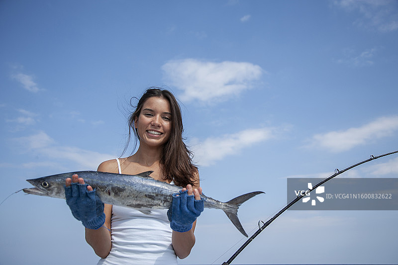 船上女人拿鱼图片素材