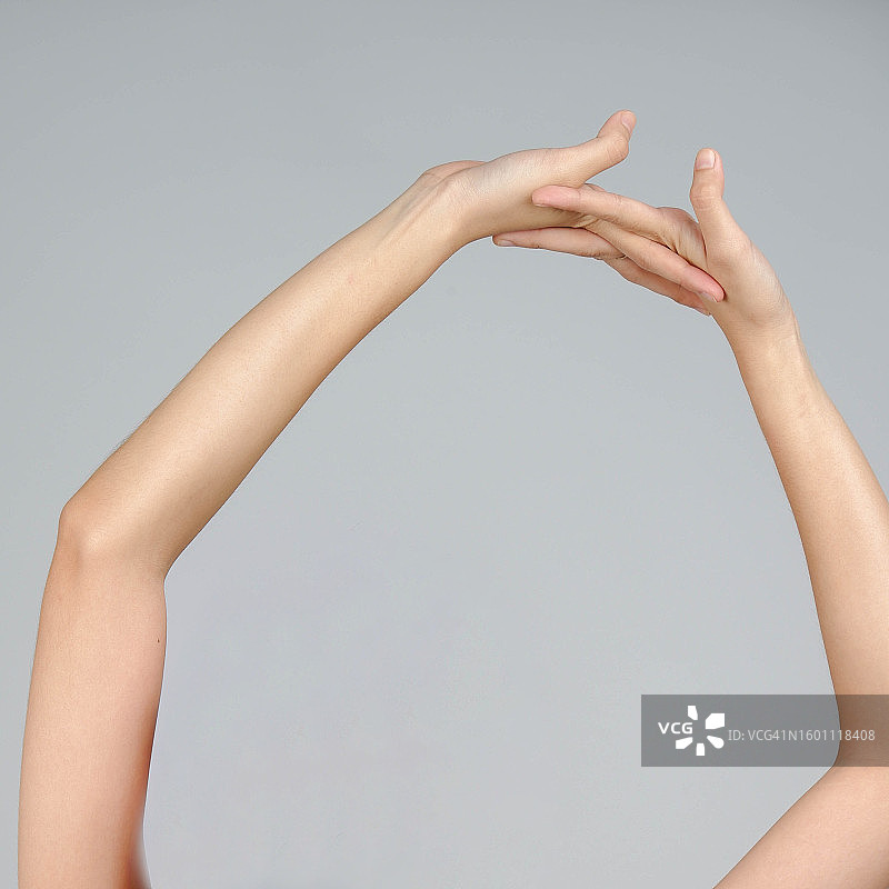 在灰色背景下做手势的女人（加利福尼亚州，美国）图片素材