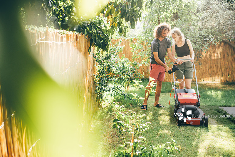 情侣在后院修剪草坪图片素材