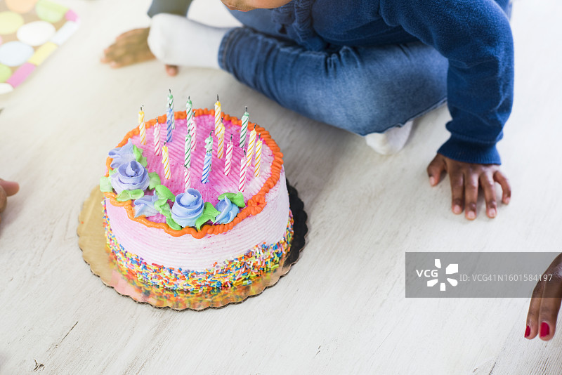 女孩吹灭生日蛋糕上的蜡烛（下半身视角）图片素材