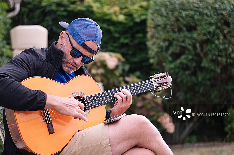 弹奏西班牙吉他的47岁白人男子图片素材