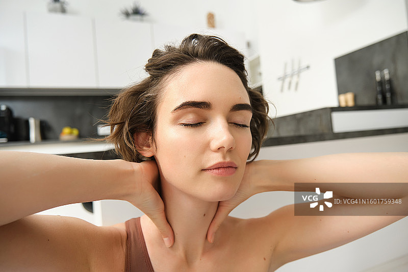 在浴室里闭着眼睛的年轻女人特写图片素材