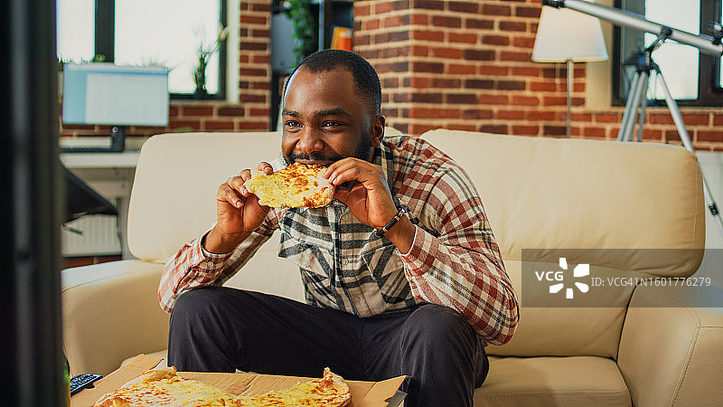 男人在家坐着吃披萨图片素材