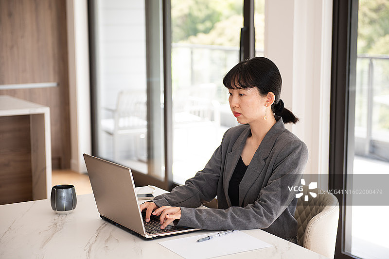 年轻女商人在家里的客厅工作图片素材