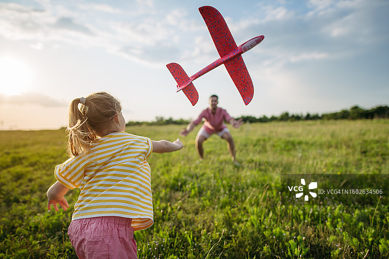 快乐的父女俩在玩泡沫滑翔机图片素材