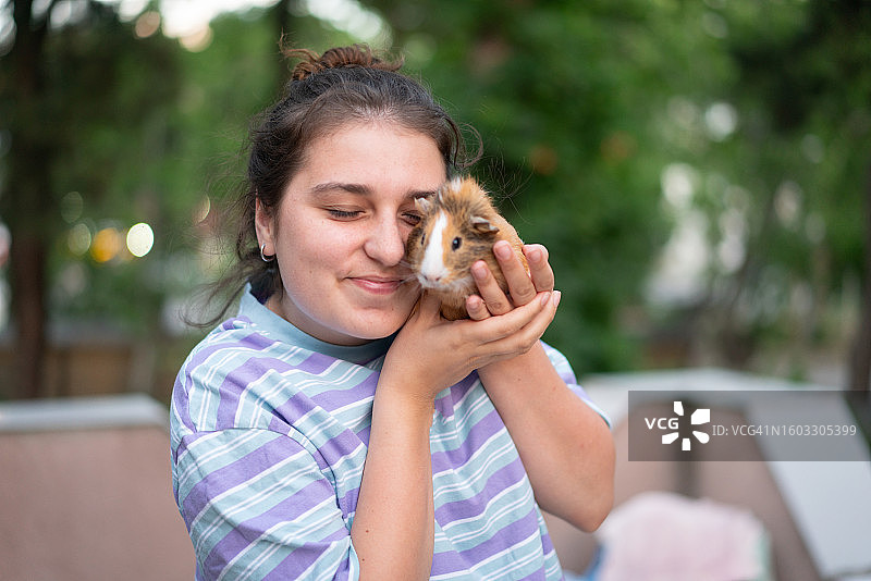 在露台上与棕色仓鼠玩耍图片素材