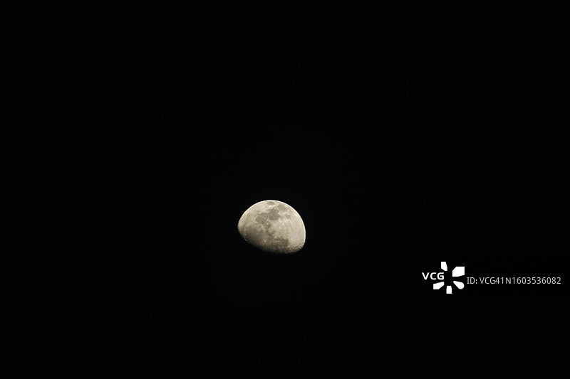 在晴朗的夜空下，月亮的低角度视图图片素材