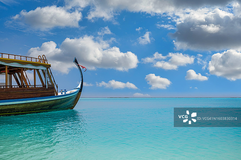 马尔代夫海滩的惊艳设计：马尔代夫传统多尼船，完美的蓝色海洋与泻湖，奢华热带天堂概念，美丽的度假旅行景观，宁静的海洋泻湖图片素材