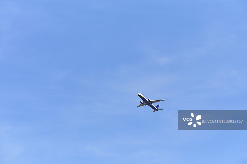 晴朗蓝天下远处飞机的仰视角度照片图片素材