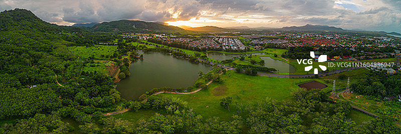 雨后群山环绕的城市、树木和绿草地航拍全景图片素材