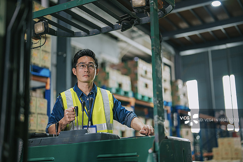 中国仓库工人用叉车装载纸箱图片素材