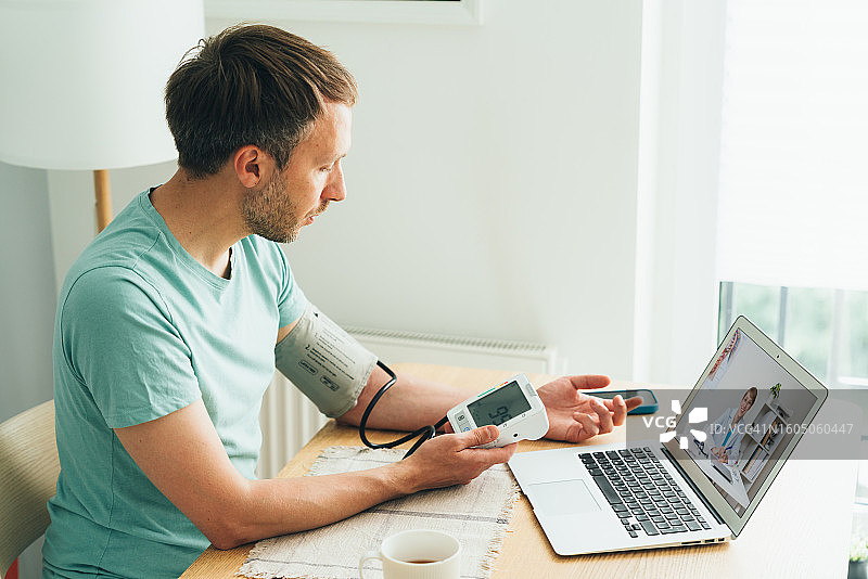 生病的男人在远程办公期间用电子脉搏计测量血压，与微笑的女医生连线，高血压疾病，患者在线呼叫治疗师，在家诊断，与医护人员进行视频会议，电子医疗概念图片素材