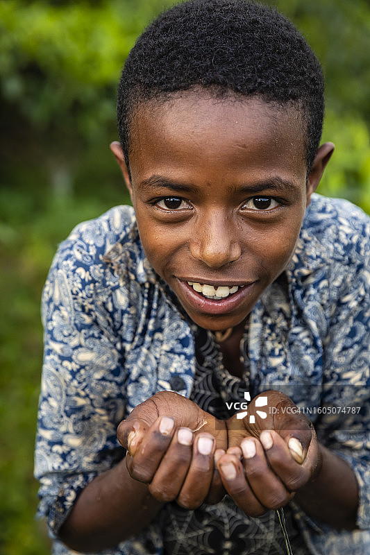 东非的非洲年轻男孩喝着淡水图片素材