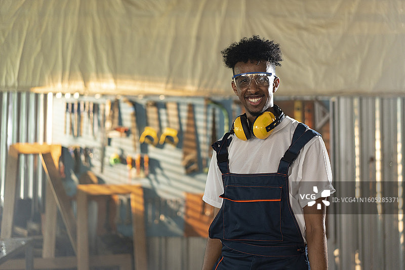 在木制家具厂工作的年轻男木匠图片素材