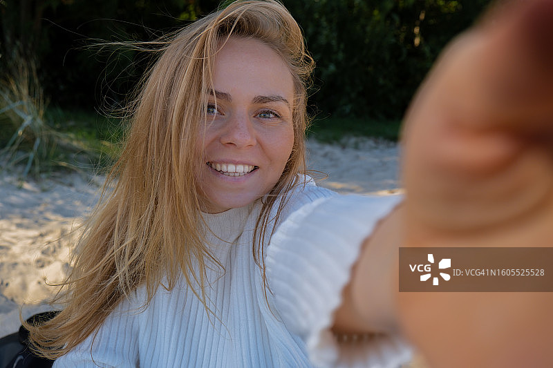 在海滩上微笑的年轻女性肖像图片素材