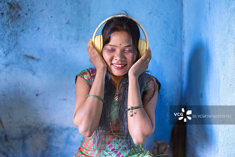 来自印度奥迪沙邦的小女孩第一次戴耳机听音乐图片素材