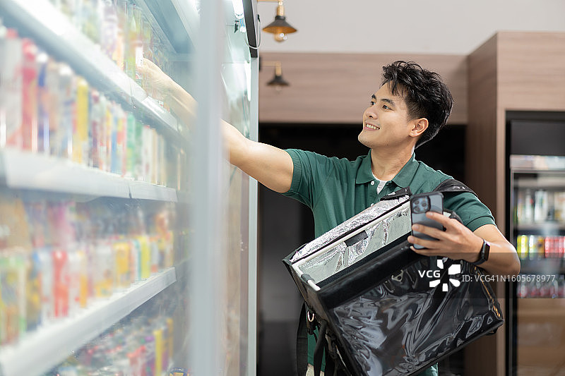 超市购物配送员为顾客购买商品，亚洲外卖员挑选食品图片素材