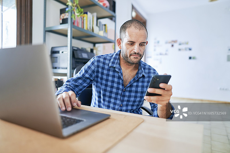 男人在办公室使用智能手机电脑图片素材