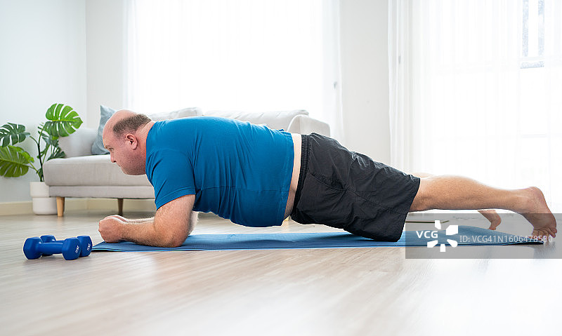 挑战刻板印象：胖白人居家锻炼茁壮成长图片素材