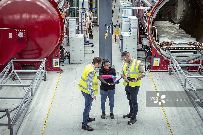 经理和工人在汽车零件工厂讨论碳纤维产品图片素材