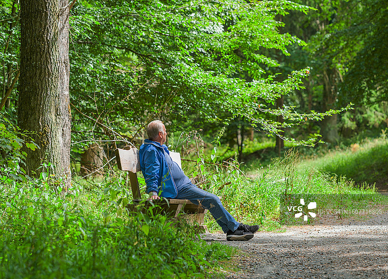 坐在公园长椅上休息的年长男人图片素材