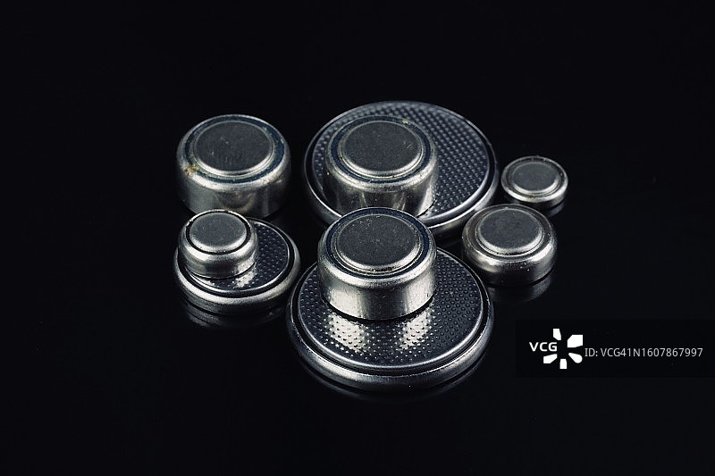 黑色背景上的纽扣电池图片素材