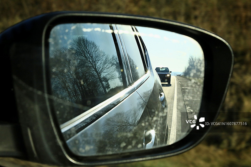 后视镜显示车辆在后方的侧视图图片素材