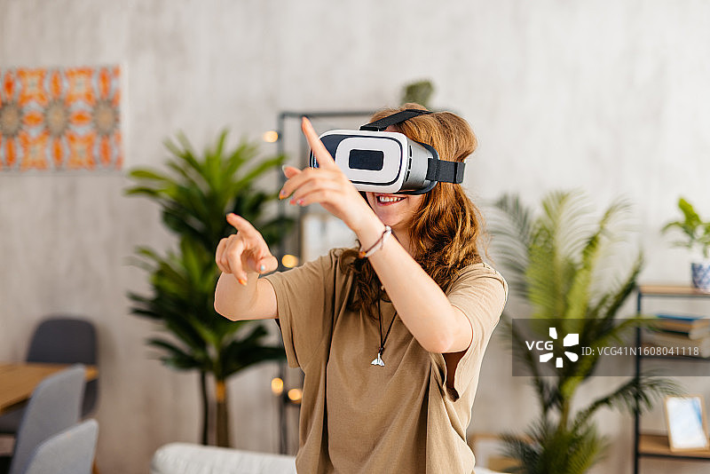 年轻女子在家中佩戴VR头显图片素材