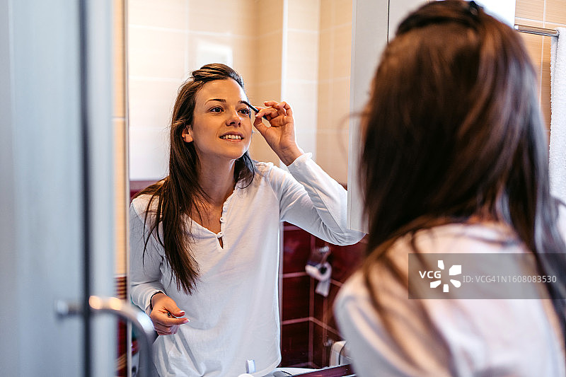年轻女人在浴室化妆图片素材