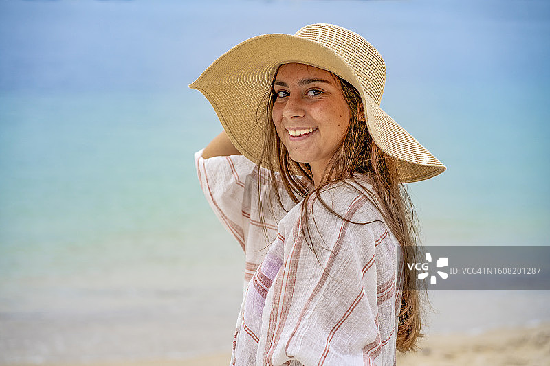 戴着帽子的迷人漂亮女孩在海滩上图片素材