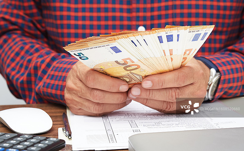 男人手持并数钱的特写，欧盟钞票图片素材