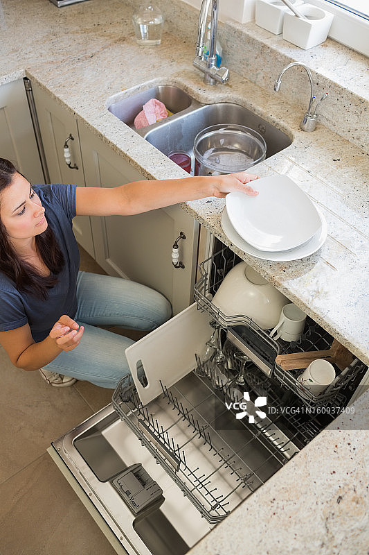 从洗碗机中卸下餐具的女人图片素材