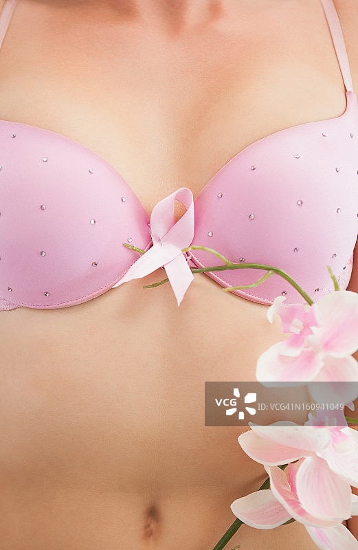 佩戴乳腺癌防治意识丝带和鲜花的女人图片素材