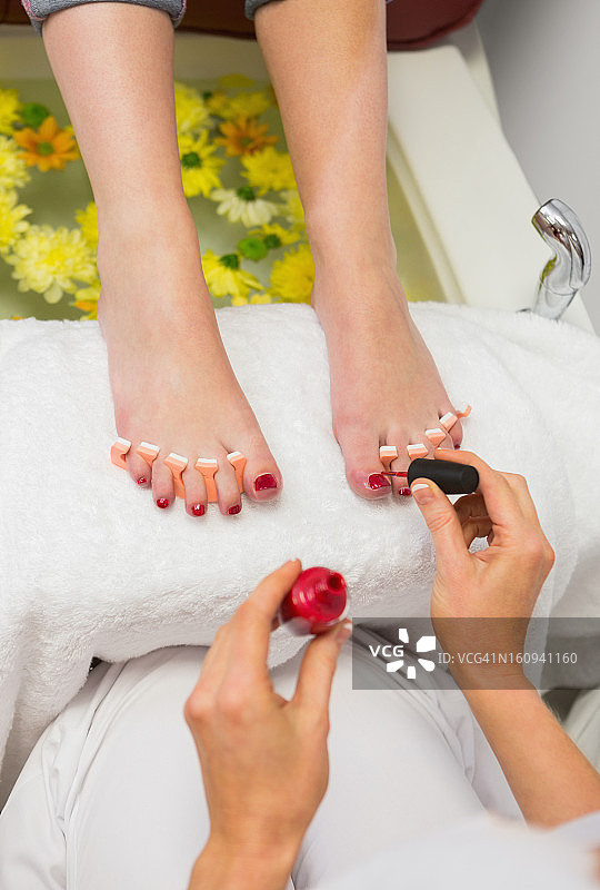 女人在水疗中心涂抹脚趾甲油图片素材