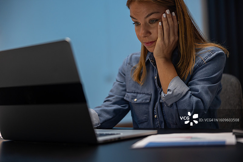 在创意办公室工作时使用笔记本电脑的女商人图片素材