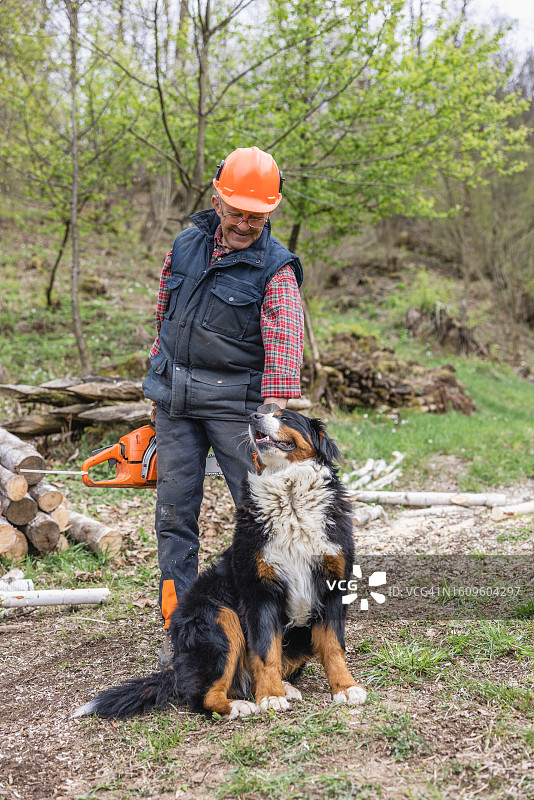在森林里抚摸狗的伐木工人图片素材
