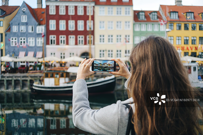 在丹麦哥本哈根用智能手机拍照的女人图片素材