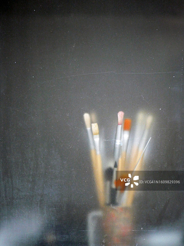 法国巴黎，透过不透明玻璃看到的罐子里的画笔图片素材