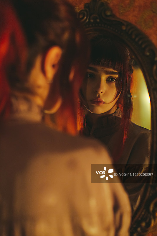 身穿紧身胸衣的红发哥特女孩。烛光图片素材