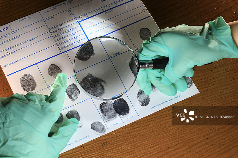 犯罪学家比较犯罪现场的指纹图片素材