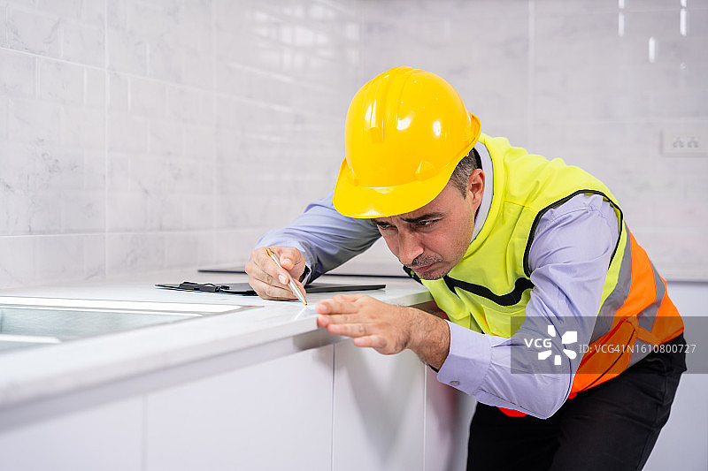 房屋检查员测量新房厨房台面的水平图片素材