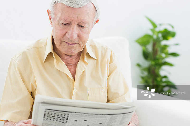 平静的老年男人在读报纸图片素材