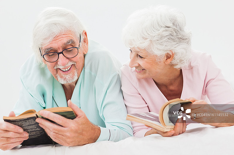 幸福夫妻在床上阅读图片素材